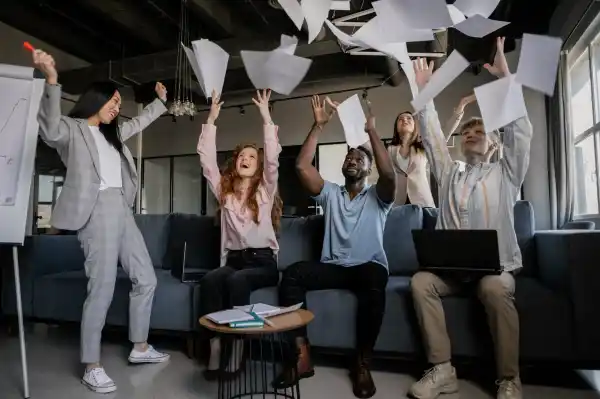 photo of coworkers throwing pieces of paper